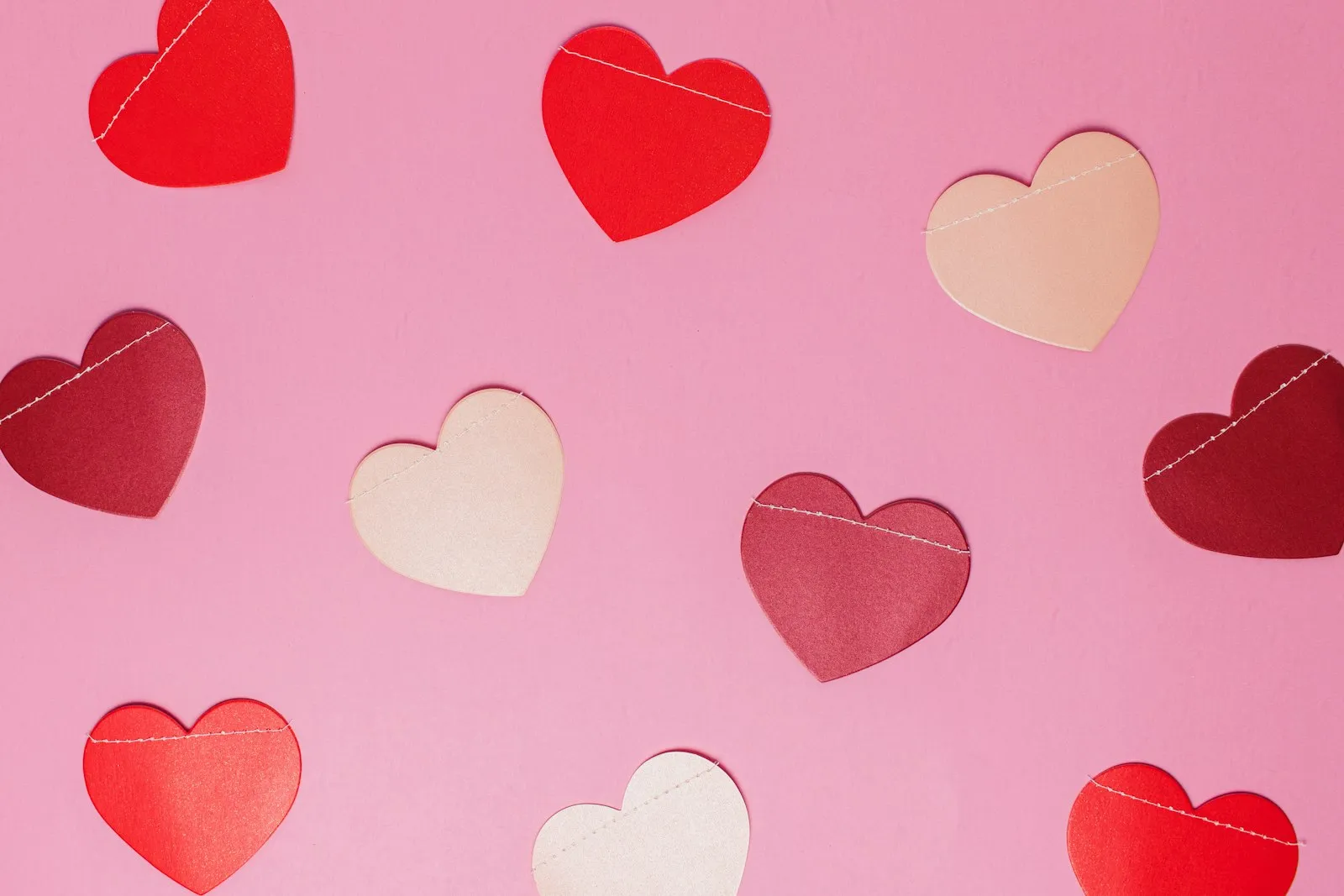 Many pink and red paper hearts scattered across a soft background, representing multiple causes.